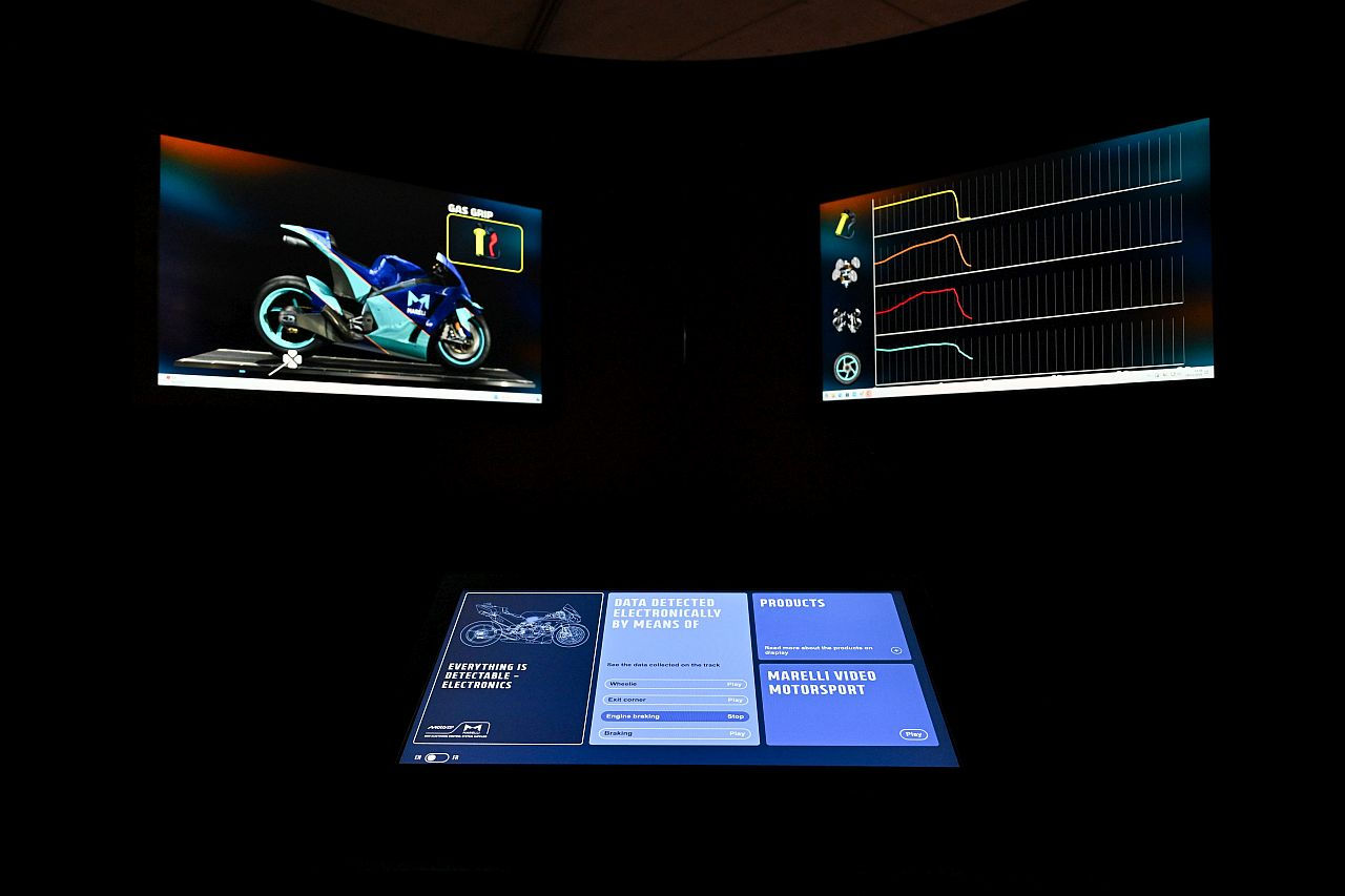 Interactive motorsport technology display with digital telemetry screens.