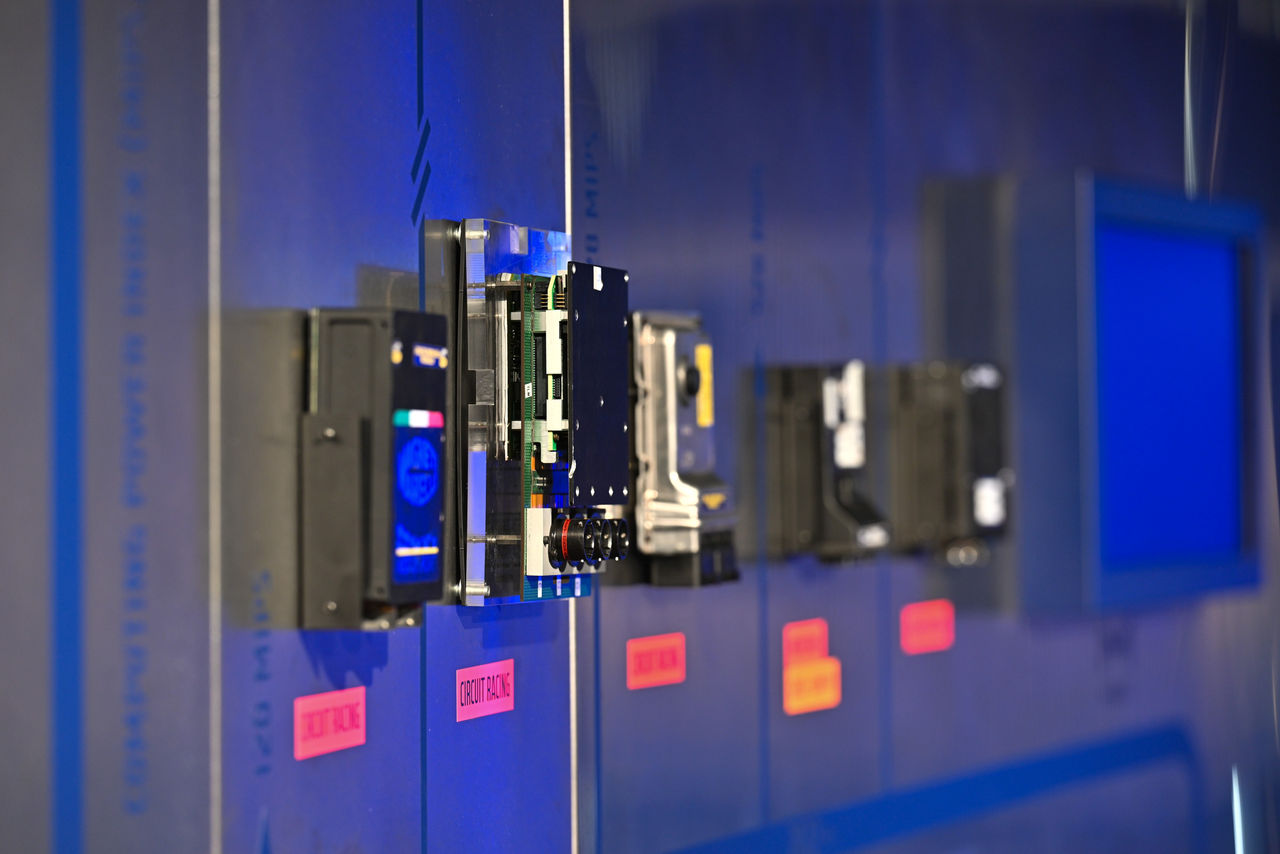 Historic electronic control units displayed in a motorsport exhibit.