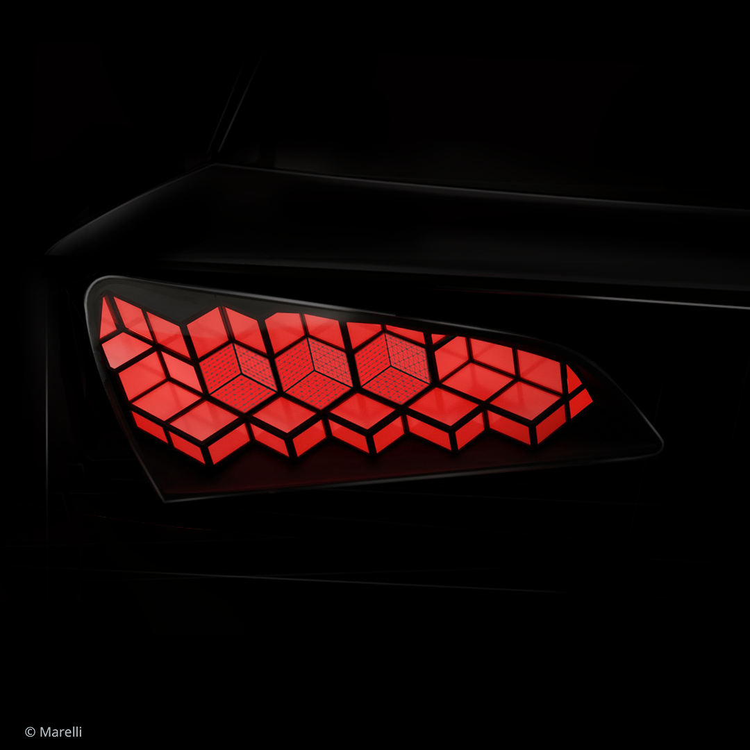  Primo piano di una luce posteriore di un’auto dal design elegante, illuminata di rosso, con un motivo geometrico a nido d’ape integrato in un pannello della carrozzeria nero lucido su sfondo scuro.