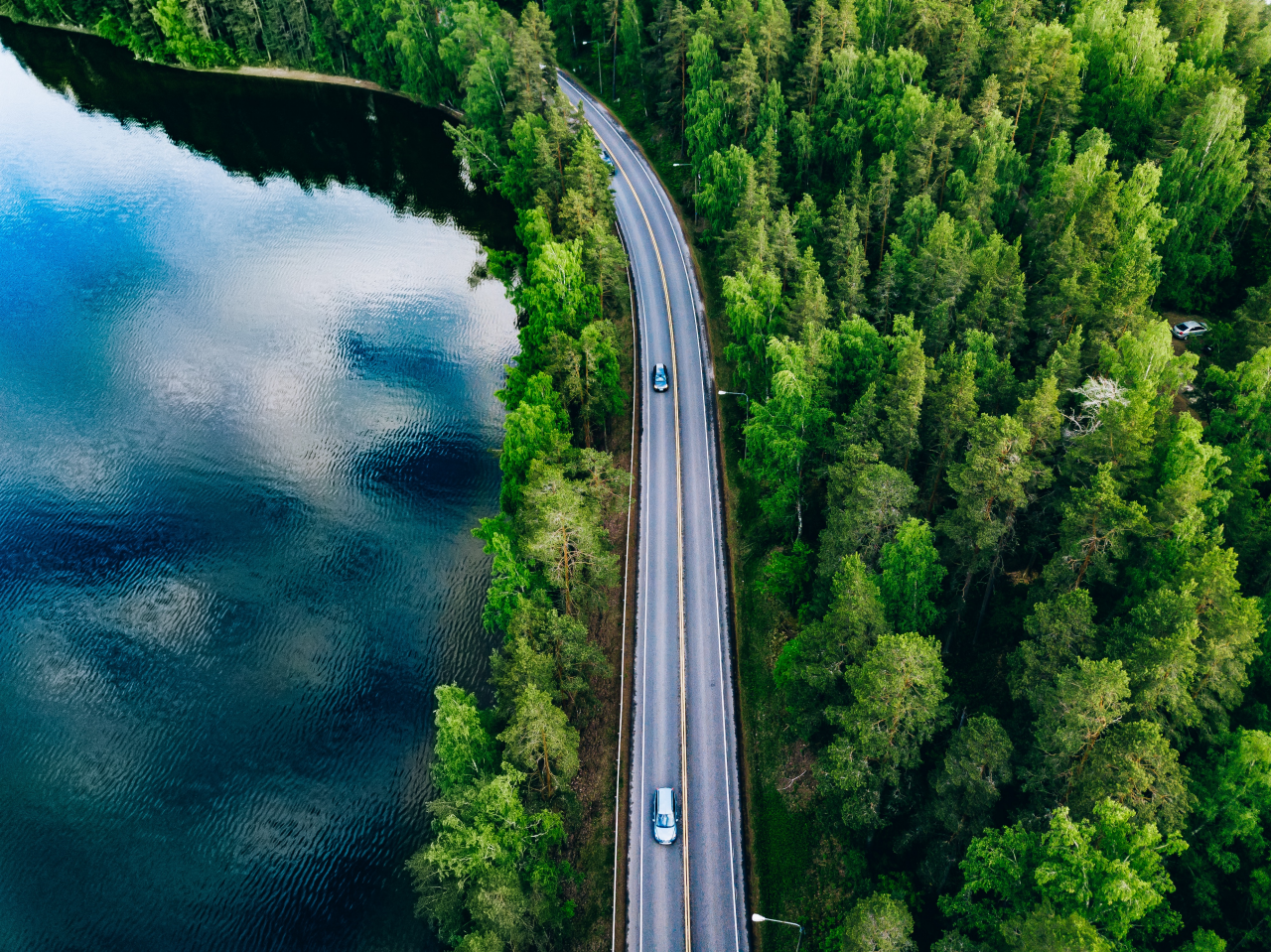 Aerial view of road between green summer forest and blue lake in Finland; Shutterstock ID 1445931623; purchase_order: -; job: -; client: -; other: -